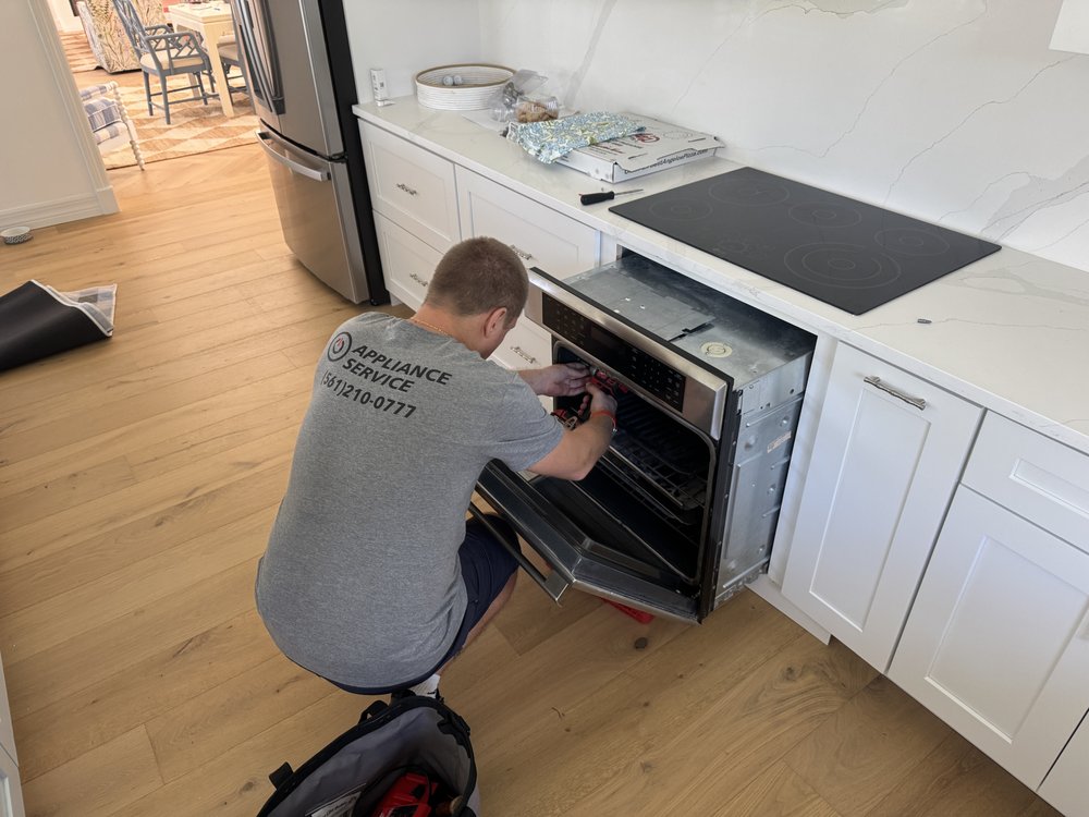 IO Appliance technician repairing oven