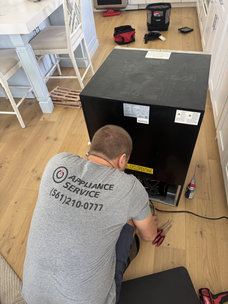 IO Appliance technician repairing wine cooler