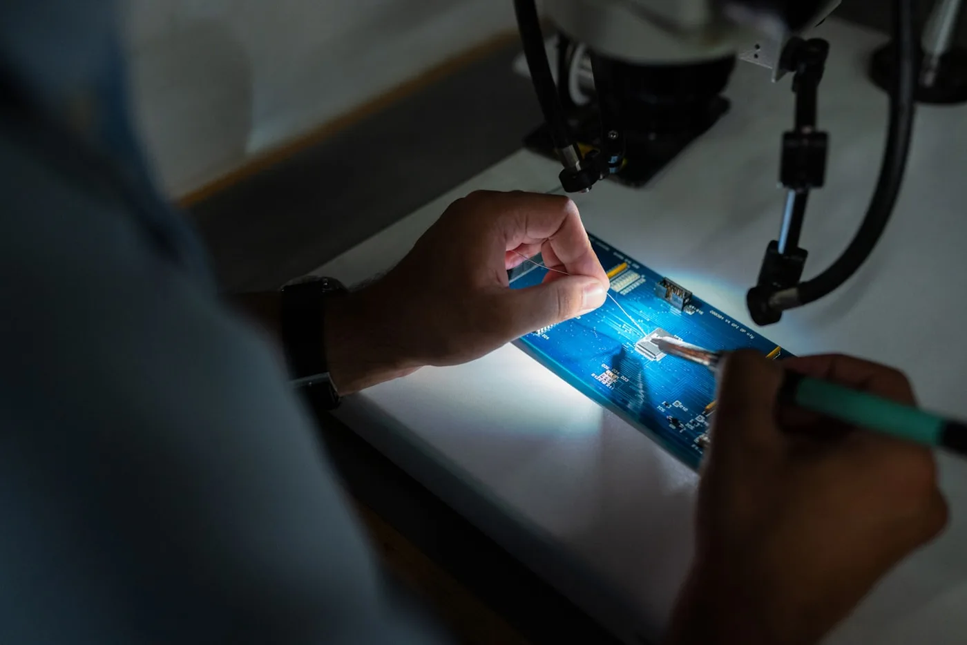 Technician soldering a circuit board at component level